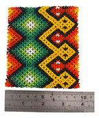 Pulseira elástica em contas coloridas com figuras em X amarelas e verdes e detalhes vermelhos