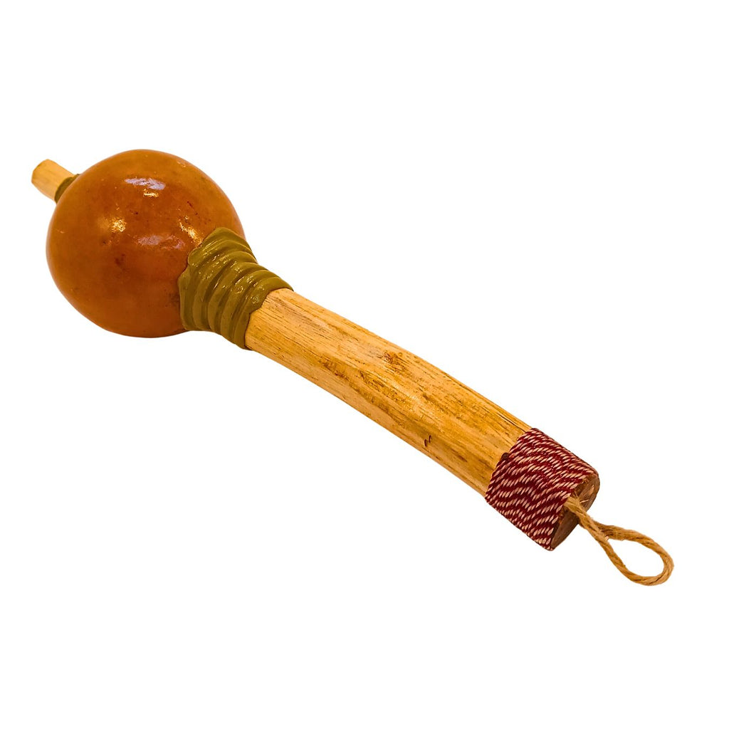 Maraca artesanal com cabaça marrom no topo e cabo de madeira, cordão na ponta