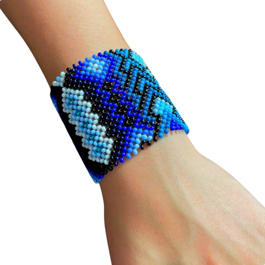 Pulseira de miçangas azul, preta e branca com padrão geométrico, estilo tribal