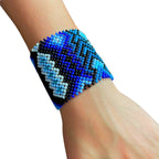 Pulseira de miçangas azul, preta e branca com padrão geométrico, estilo tribal