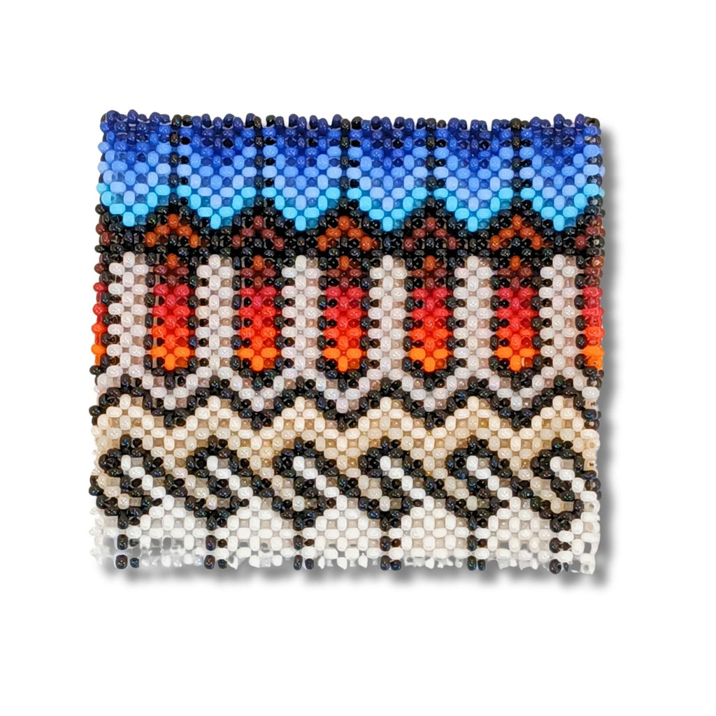 Pulseira indígena em miçangas com padrão geométrico azul, laranja, vermelho e preto