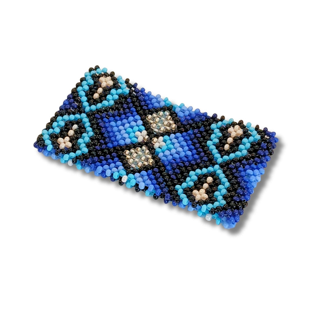 Pulseira de miçangas azul com padrão geométrico preto e tons claros.