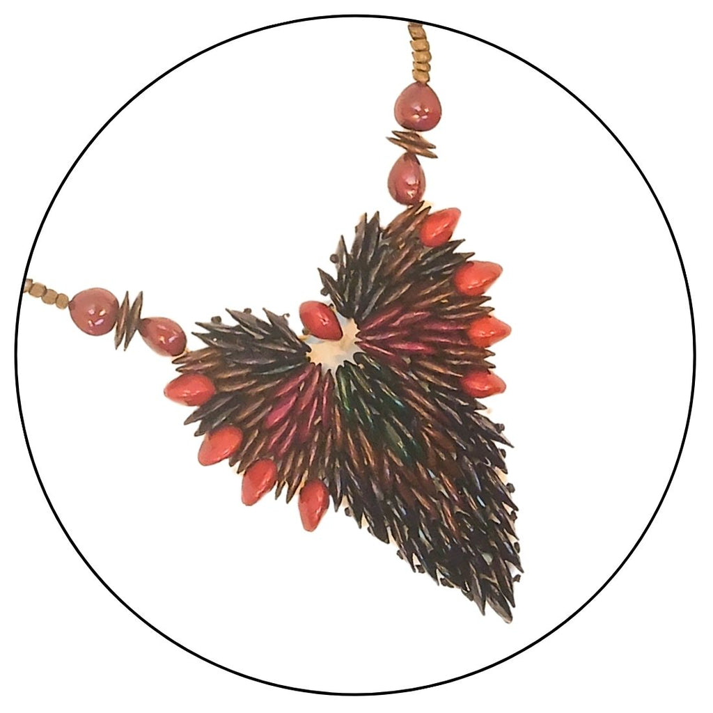 Colar de sementes com cordão marrom e pingente folha escuro com detalhes vermelhos