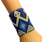 Pulseira de miçangas azul com detalhes pretos e brancos, elástica, estilo indígena.