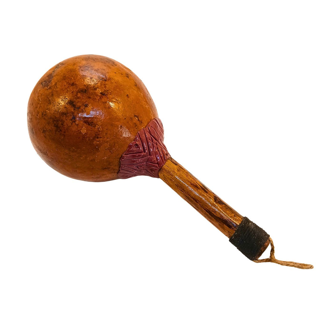 Maraca Cabocla Kaxinawa com cabaça marrom e cabo de madeira, detalhes entalhados no punho