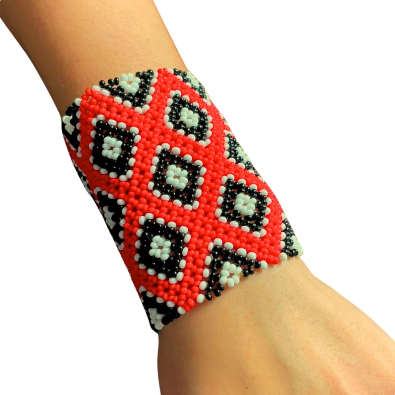 Pulseira de miçangas vermelha e preta com desenhos geométricos, no pulso