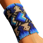 Pulseira de miçangas azul e preta com padrão geométrico e detalhes prateados