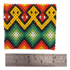 Pulseira elástica Fulni-ô com miçangas coloridas e padrão repetido de losangos e círculos brancos