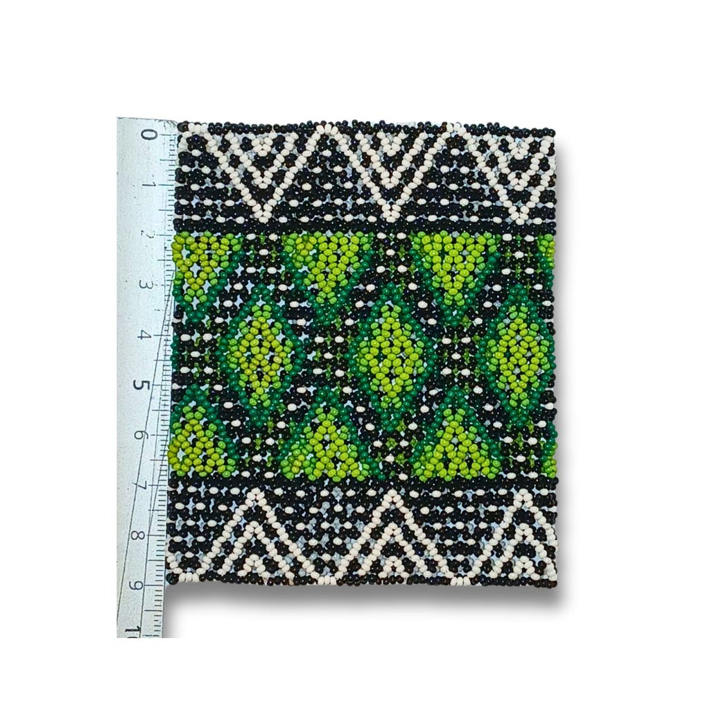 Pulseira de miçangas com padrão preto, branco e verde-limão, com régua ao lado