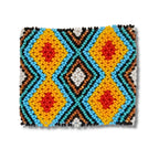 Pulseira de miçangas com estampa geométrica simétrica em azul, amarelo e vermelho, com detalhes brancos