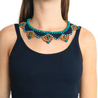 Colar de sementes em camadas no pescoço, miçangas turquesa com apliques dourados.