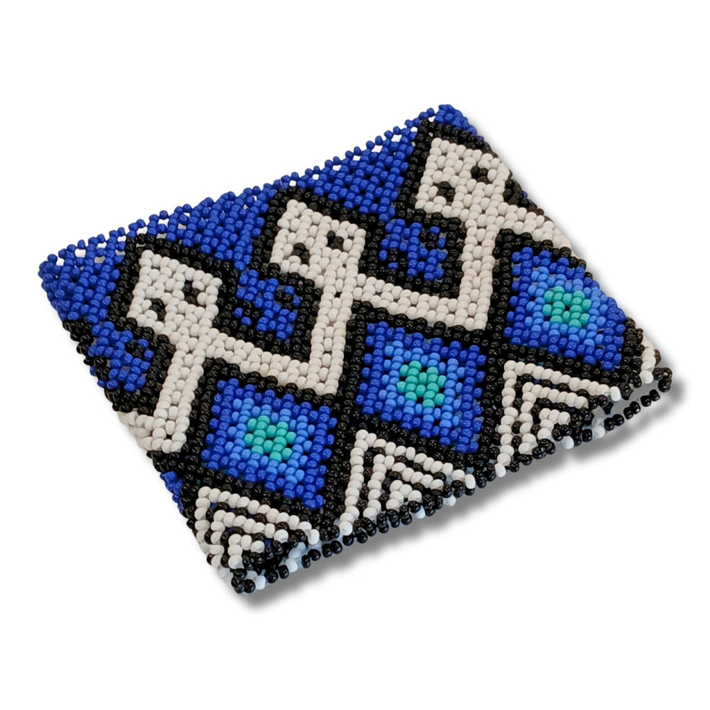Pulseira de miçangas azul e branca com desenho geométrico preto, em tira larga.