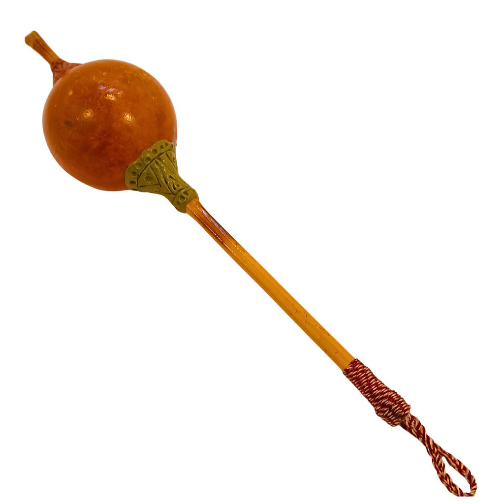 Maraca de cabaça marrom com cabo de madeira e cordão trançado vermelho e verde